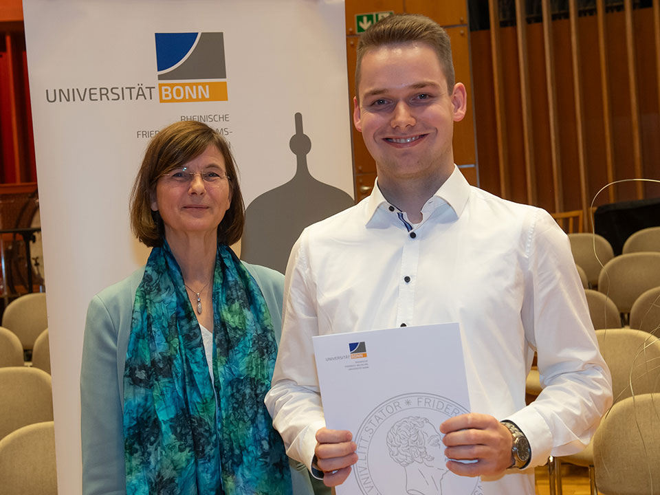 Prof. Dr. Monika Hartmann, stellv. Vorsitzender der Theodor Brinkmann-Stiftung, überreicht dem Stipendiaten Jens Schots die Urkunde.